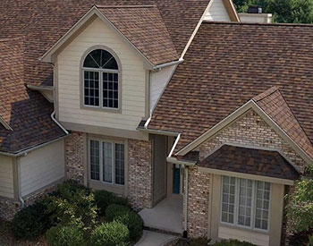 Front view of residential home with red-ish Owens Corning shingles on its roof